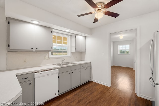 kitchen featuring white appliances, white cabinets, sink, dark hardwood / wood-style floors, and ceiling fan