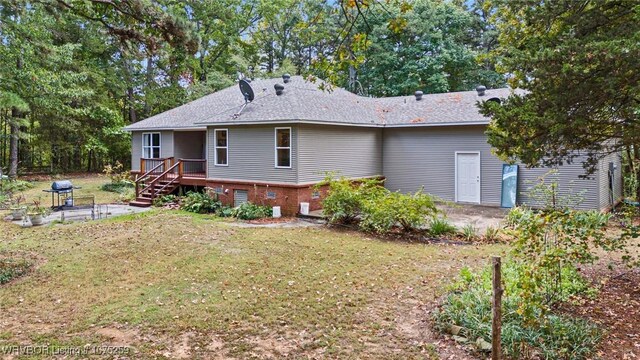 rear view of house featuring a lawn, a patio, and a wooden deck