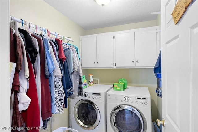 clothes washing area with cabinets, independent washer and dryer, and a textured ceiling