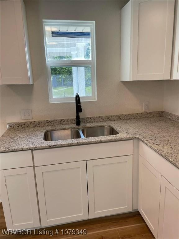 kitchen with white cabinetry, dark wood finished floors, and a sink