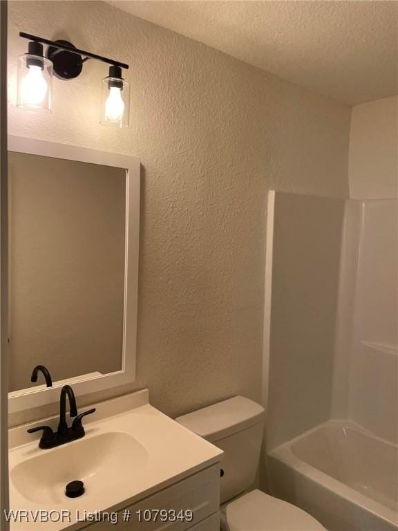 full bath featuring shower / bathing tub combination, a textured wall, toilet, a textured ceiling, and vanity