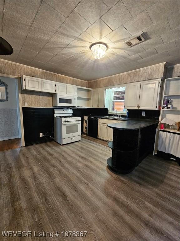 kitchen with white appliances, dark hardwood / wood-style floors, sink, and white cabinets