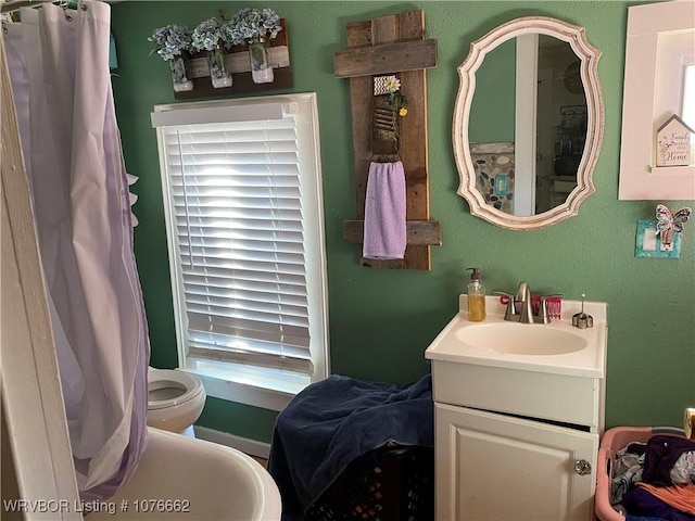 bathroom featuring vanity, toilet, and a wealth of natural light