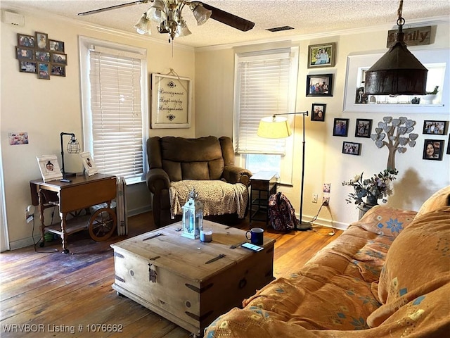 living room with plenty of natural light, crown molding, wood-type flooring, and a textured ceiling