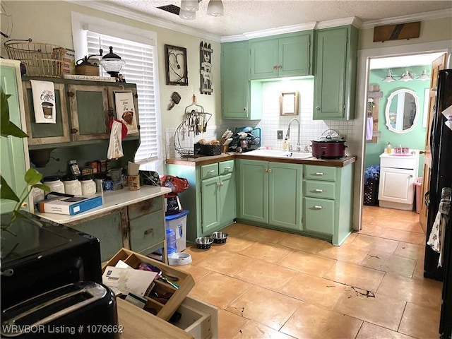 kitchen with light tile patterned flooring, sink, backsplash, and green cabinetry