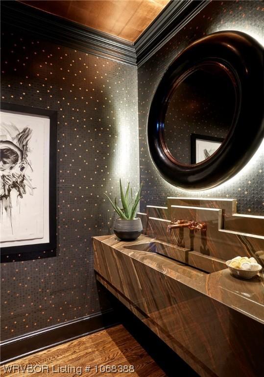 bathroom featuring sink, hardwood / wood-style floors, and ornamental molding