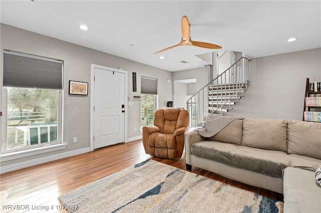 living area with a ceiling fan, baseboards, recessed lighting, stairs, and wood-type flooring