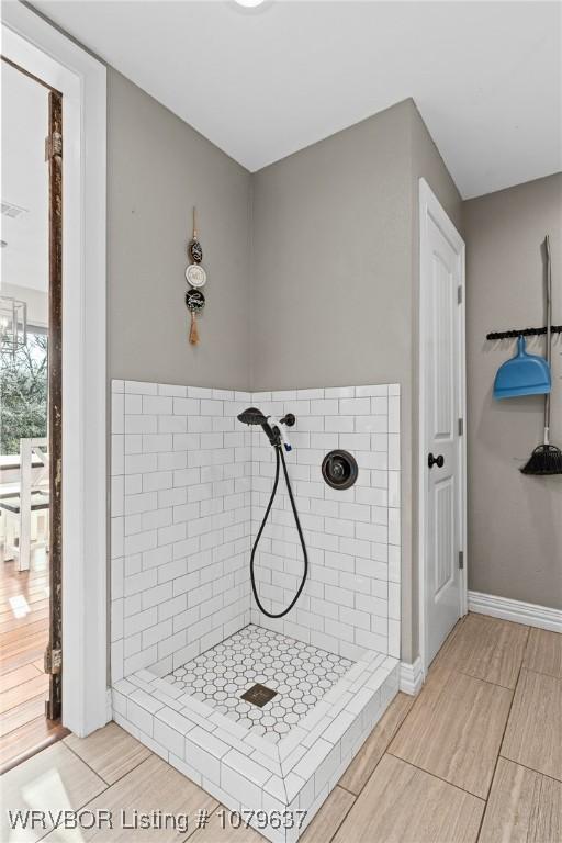 bathroom featuring a shower stall and baseboards