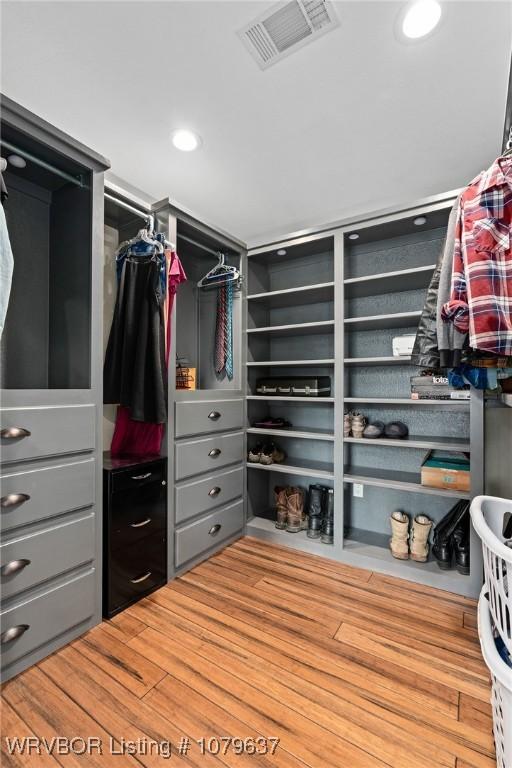 walk in closet featuring visible vents and wood finished floors