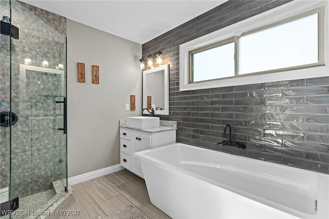 full bath with a freestanding tub, baseboards, a stall shower, and vanity