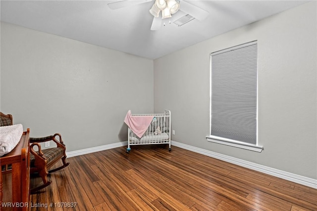 unfurnished room featuring a ceiling fan, wood finished floors, and baseboards