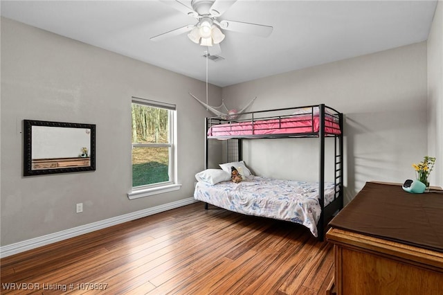 bedroom with ceiling fan, wood finished floors, visible vents, and baseboards