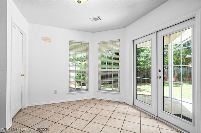 1121 Bourland St, Arkoma, OK 74901 - doorway to outside with healthy amount of natural light, a textured ceiling, and light tile patterned floors