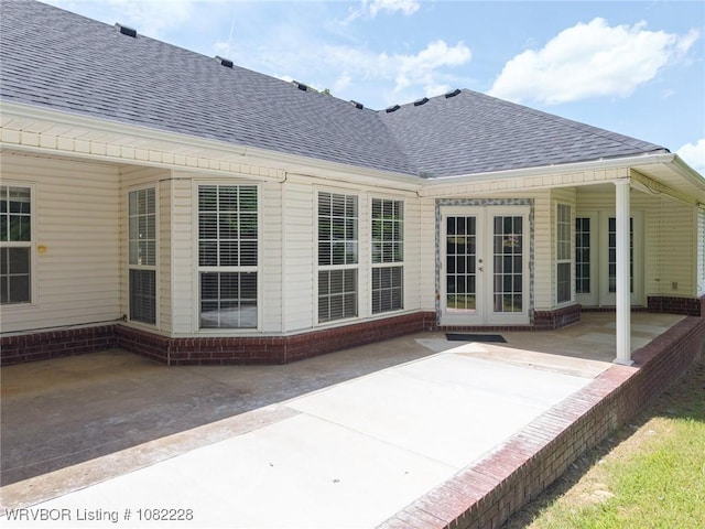 1121 Bourland St, Arkoma, OK 74901 - rear view of property featuring a shingled roof, french doors, a patio area, and brick siding