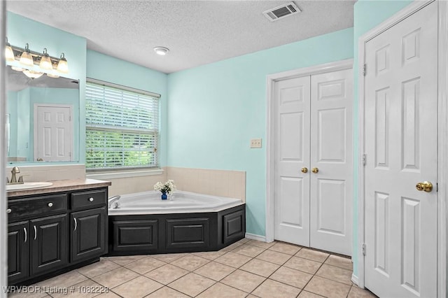 1121 Bourland St, Arkoma, OK 74901 - full bath with a closet, vanity, a bath, tile patterned flooring, and a textured ceiling