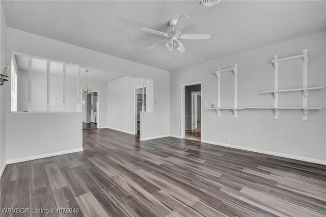 unfurnished living room with dark hardwood / wood-style flooring, ceiling fan with notable chandelier, and a textured ceiling