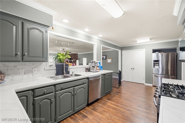 8005 Holly Ave, Fort Smith, AR 72908 - kitchen featuring crown molding, light countertops, dark wood-style floors, stainless steel appliances, and a sink