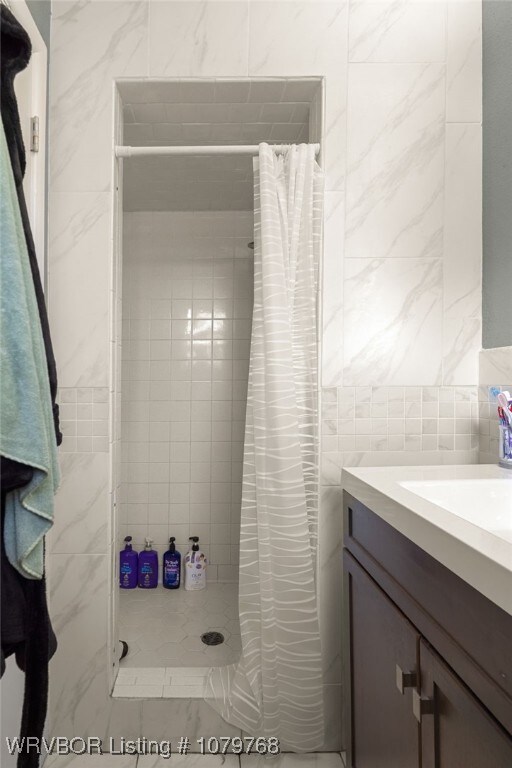 8005 Holly Ave, Fort Smith, AR 72908 - full bath featuring vanity, tile walls, a tile shower, and decorative backsplash