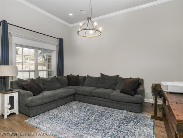 living room featuring crown molding, a chandelier, and hardwood / wood-style floors