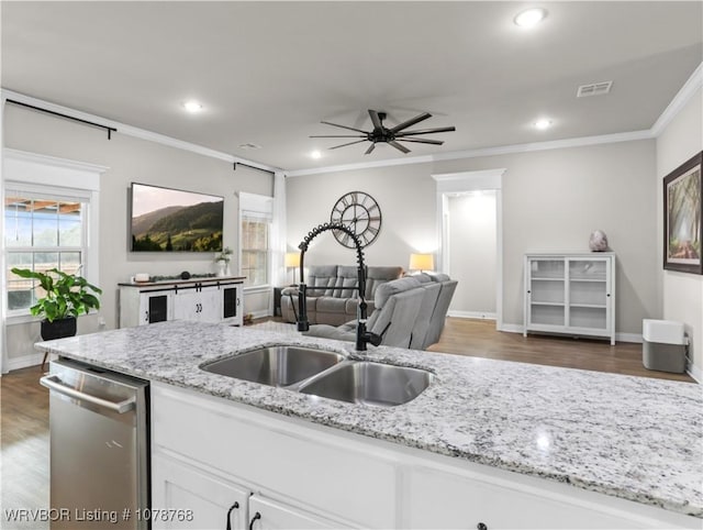 kitchen with sink, white cabinetry, light stone counters, stainless steel dishwasher, and ornamental molding