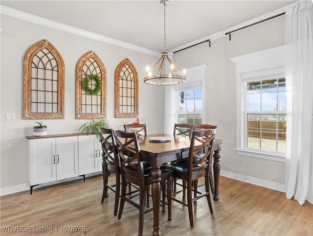 dining area with an inviting chandelier, hardwood / wood-style floors, and ornamental molding