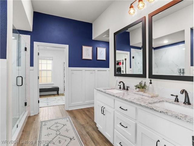 bathroom featuring vanity, wood-type flooring, and a shower with shower door