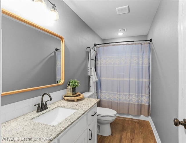 full bathroom featuring vanity, wood-type flooring, toilet, and shower / bath combo with shower curtain