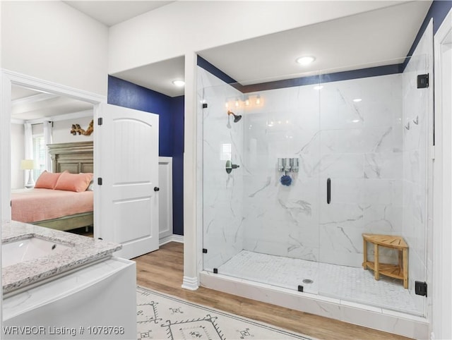 bathroom with walk in shower, sink, and hardwood / wood-style floors