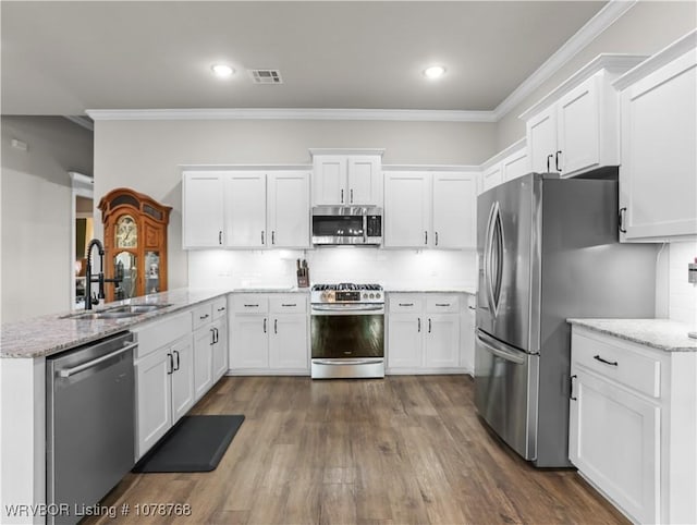 kitchen featuring sink, white cabinets, light stone counters, kitchen peninsula, and stainless steel appliances