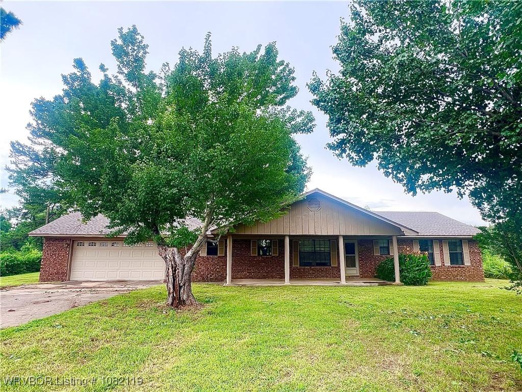 113749 4758th Rd, Muldrow, OK 74948 - single story home with driveway, a front lawn, brick siding, a porch, and a garage