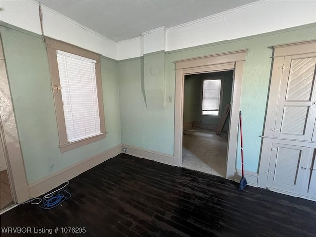 empty room featuring dark hardwood / wood-style flooring and crown molding