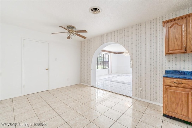903 O St, Barling, AR 72923 - unfurnished dining area featuring wallpapered walls, arched walkways, a ceiling fan, and light tile patterned flooring