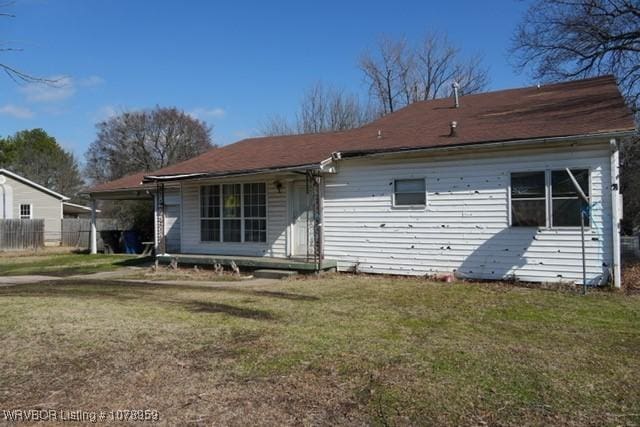 rear view of property with a yard and fence