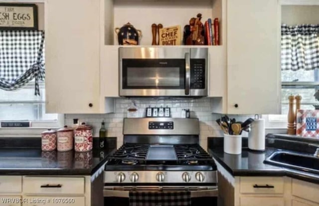 kitchen featuring backsplash, white cabinetry, plenty of natural light, and stainless steel appliances