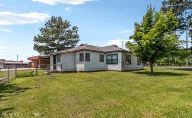 rear view of property featuring a yard