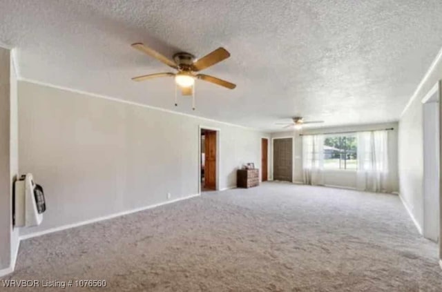 carpeted spare room featuring ceiling fan and a textured ceiling