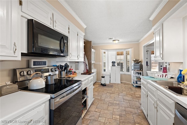 kitchen featuring white cabinets, ornamental molding, stainless steel appliances, and light countertops