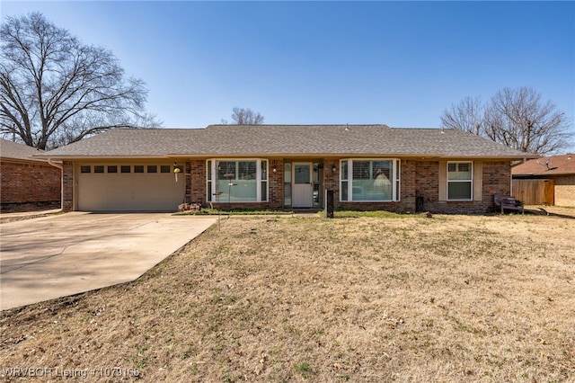 ranch-style house featuring a garage, brick siding, a shingled roof, concrete driveway, and a front yard