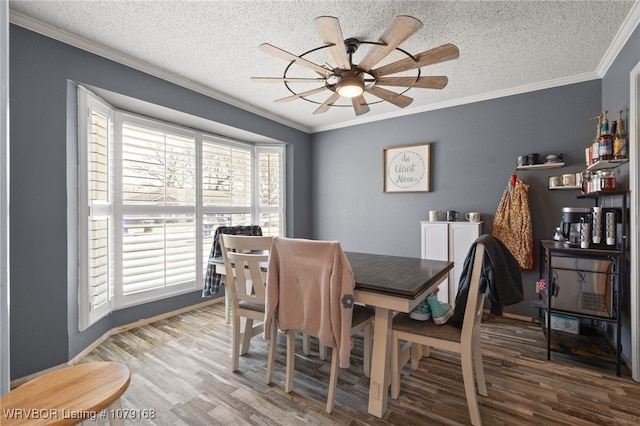 dining room featuring a textured ceiling, ceiling fan, wood finished floors, and crown molding