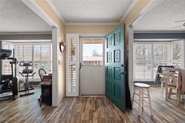 foyer featuring crown molding, a textured ceiling, and wood finished floors