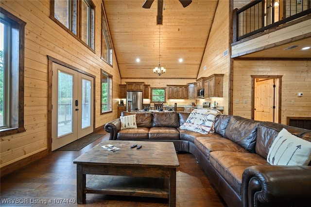 living room with wooden walls, french doors, high vaulted ceiling, and dark wood-type flooring