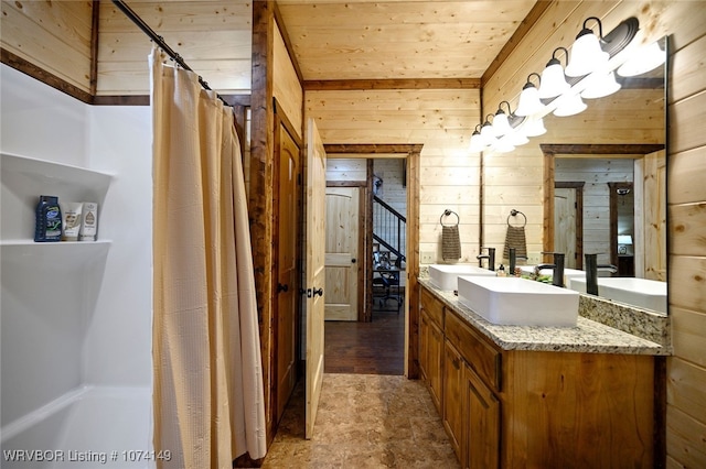 bathroom featuring a shower with shower curtain, vanity, wood walls, and wood ceiling