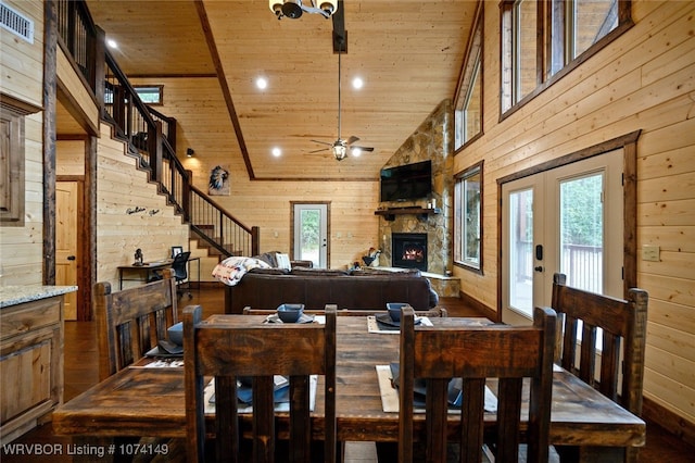 dining room with wooden walls, high vaulted ceiling, wood ceiling, and ceiling fan