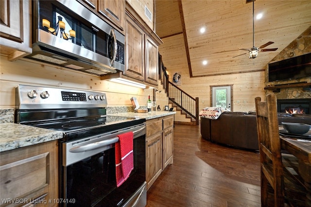 kitchen with wooden ceiling, light stone counters, dark hardwood / wood-style floors, wood walls, and appliances with stainless steel finishes