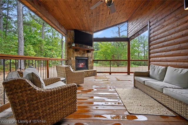 deck with an outdoor living space with a fireplace