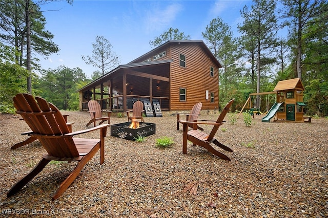 exterior space featuring a playground and an outdoor fire pit