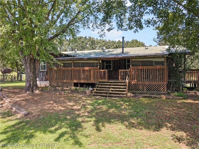 rear view of property featuring a yard and a deck