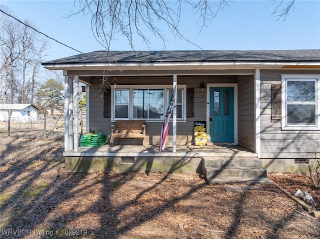 exterior space featuring roof with shingles, a porch, and crawl space