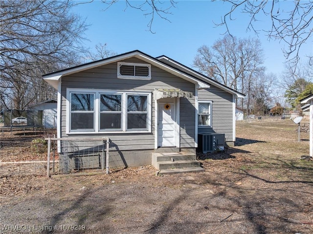 view of front of home with entry steps, fence, and central AC