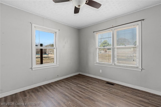 unfurnished room with plenty of natural light, baseboards, and wood finished floors